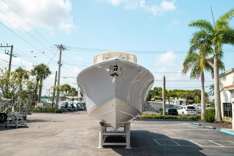 Slide: The Image of 2024 Cobia 301 CC boat on display in a sunny outdoor setting. - 7