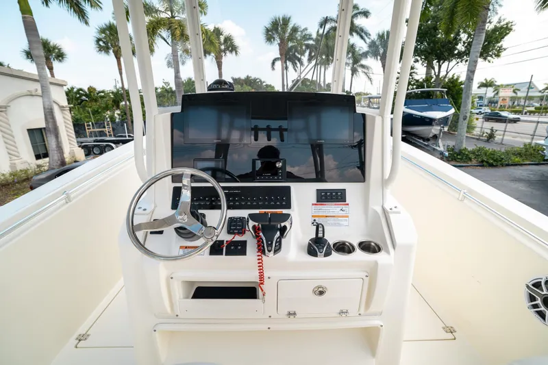 Slide: The Image of 2024 Cobia 301 CC boat helm with steering wheel and control panel. - 9