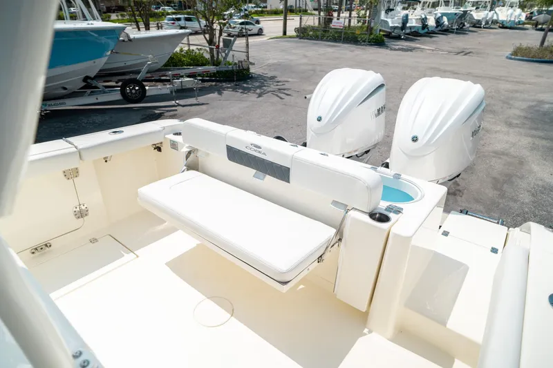 Slide: The Image of 2024 Cobia 301 CC boat with dual outboard engines and spacious seating area. - 26