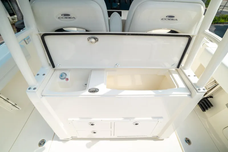 Slide: The Image of 2024 Cobia 301 CC boat interior with storage compartments and seating. - 31