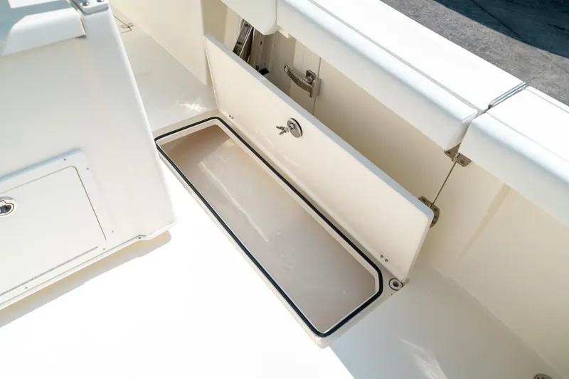 Slide: The Image of 2024 Cobia 301 CC boat storage compartment with open hatch, showcasing spacious interior. - 34