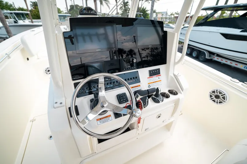 Slide: The Image of 2024 Cobia 301 CC boat helm with steering wheel and electronic displays. - 12