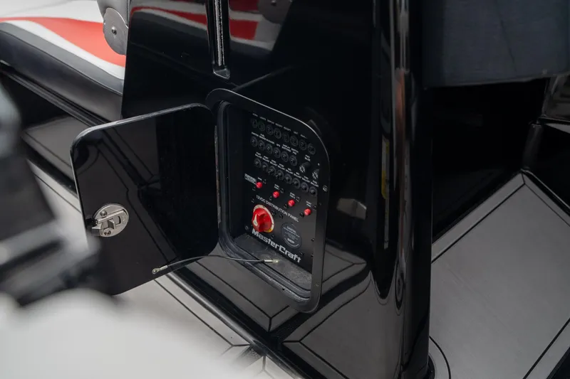 Slide: The Image of 2019 MasterCraft X-Star control panel with open compartment, showcasing switches and red knob. - 14