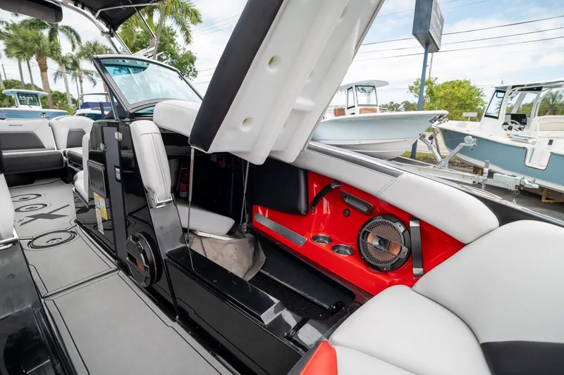 Slide: The Image of 2019 MasterCraft X-Star interior with open storage, red accents, and speaker system. - 24