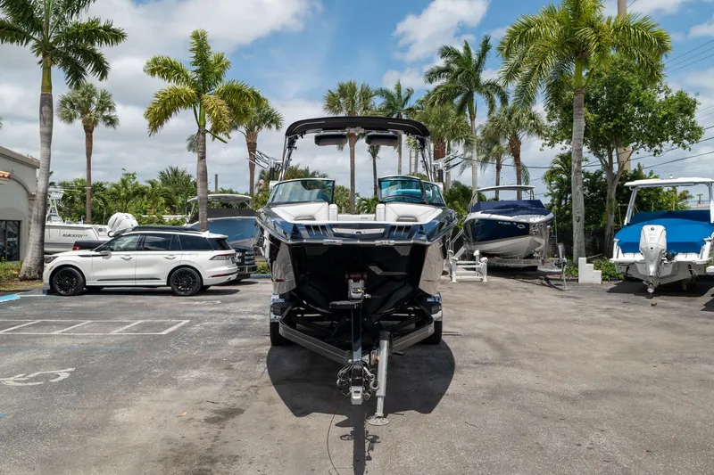 Slide: The Image of 2019 MasterCraft X-Star boat on trailer, surrounded by palm trees and parked vehicles. - 3