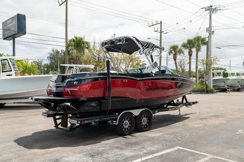 Slide: The Image of 2019 MasterCraft X-Star boat on trailer, red and black design, parked outdoors. - 6