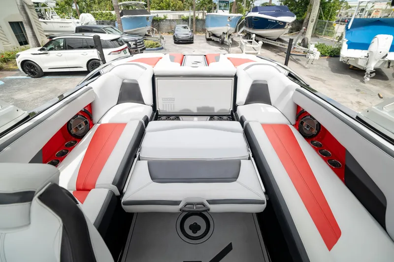 Slide: The Image of 2019 MasterCraft X-Star boat interior with red and gray seating, cup holders, and speakers. - 8