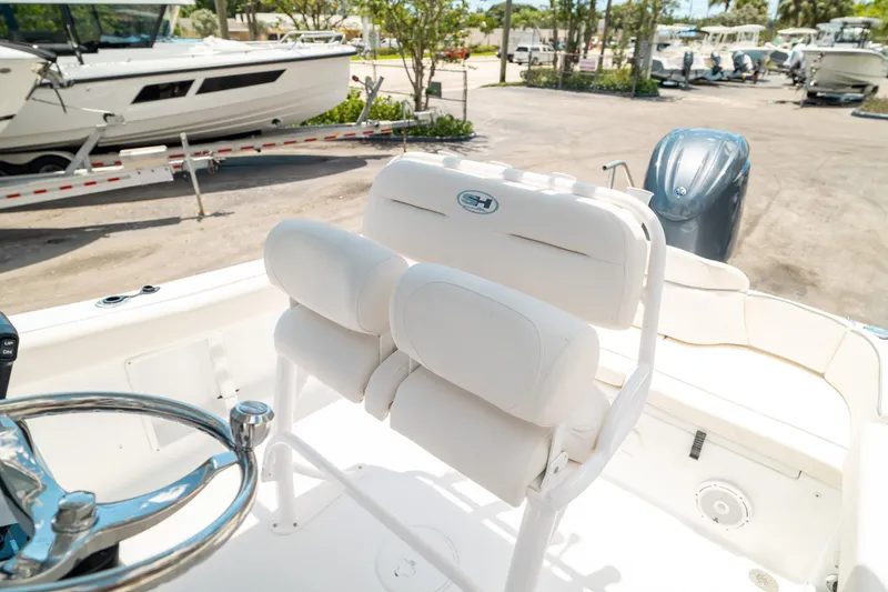 Slide: The Image of 2025 Sea Hunt Ultra 219 boat interior with white seating and steering wheel. - 12