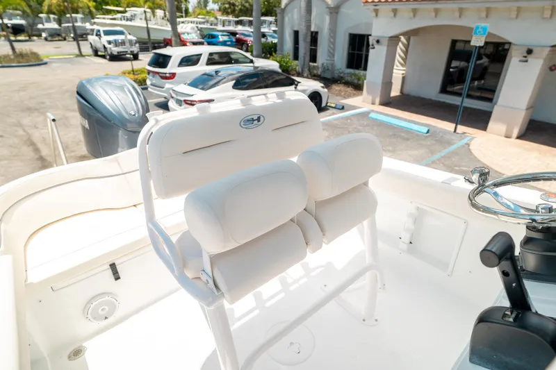 Slide: The Image of 2025 Sea Hunt Ultra 219 boat interior with white seating and steering wheel. - 13