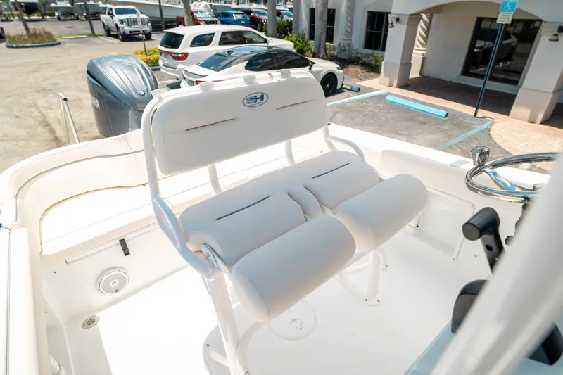 Slide: The Image of 2025 Sea Hunt Ultra 219 boat interior with white seating and steering wheel. - 14