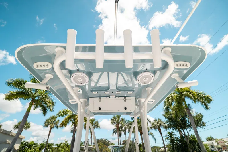 Slide: The Image of 2025 Sea Hunt Ultra 219 boat canopy with rod holders, speakers, and blue sky background. - 16