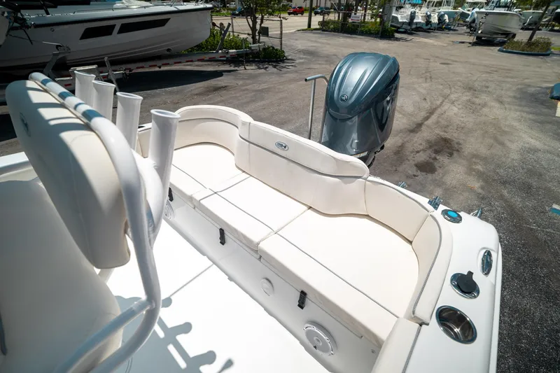 Slide: The Image of 2025 Sea Hunt Ultra 219 boat interior with seating and motor, parked on a sunny day. - 20
