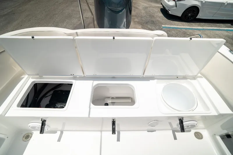 Slide: The Image of 2025 Sea Hunt Ultra 219 boat storage compartments open, showcasing interior features. - 22