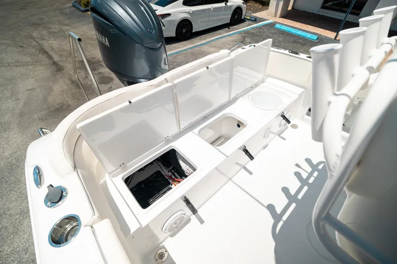 Slide: The Image of 2025 Sea Hunt Ultra 219 boat interior with open storage compartments and Yamaha engine. - 23