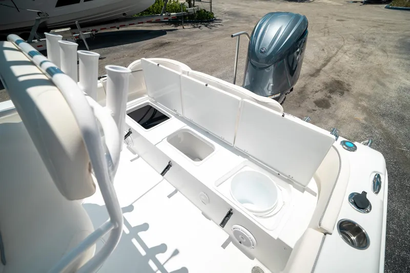 Slide: The Image of 2025 Sea Hunt Ultra 219 boat with open storage compartments and outboard motor. - 24