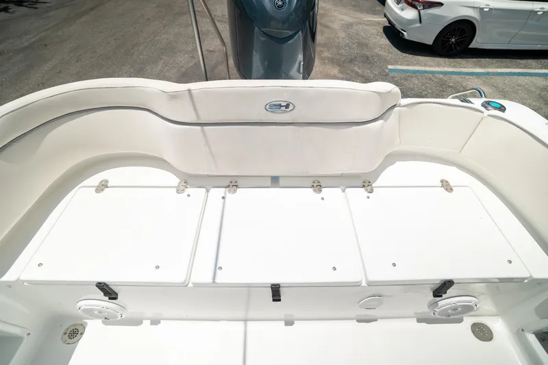 Slide: The Image of 2025 Sea Hunt Ultra 219 boat interior, featuring white seating and storage compartments. - 25