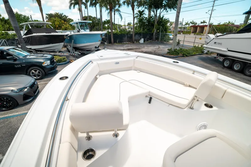 Slide: The Image of 2025 Sea Hunt Ultra 219 boat with spacious seating, parked near other boats and cars. - 30