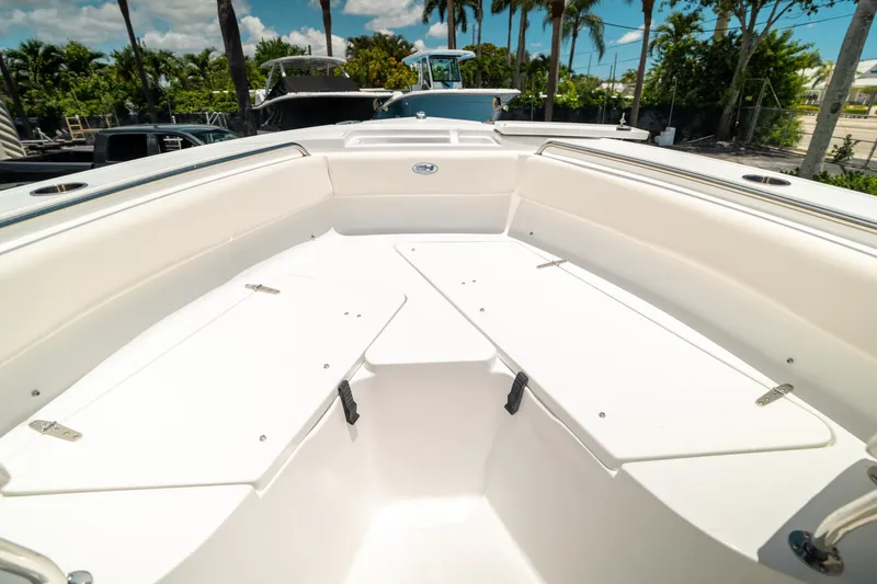 Slide: The Image of 2025 Sea Hunt Ultra 219 boat interior with white seating and storage compartments. - 33