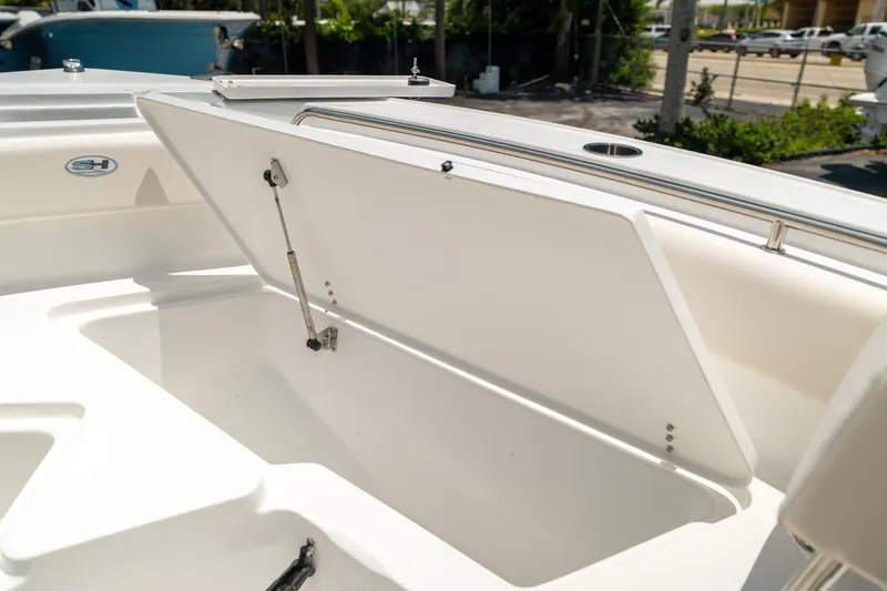Slide: The Image of 2025 Sea Hunt Ultra 219 boat storage compartment open, showcasing interior space. - 37