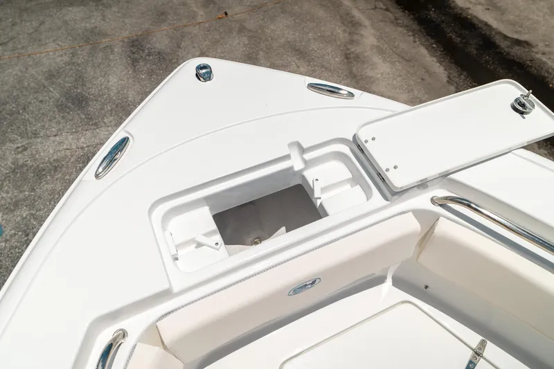 Slide: The Image of 2025 Sea Hunt Ultra 219 boat bow storage compartment, open lid, white interior. - 38