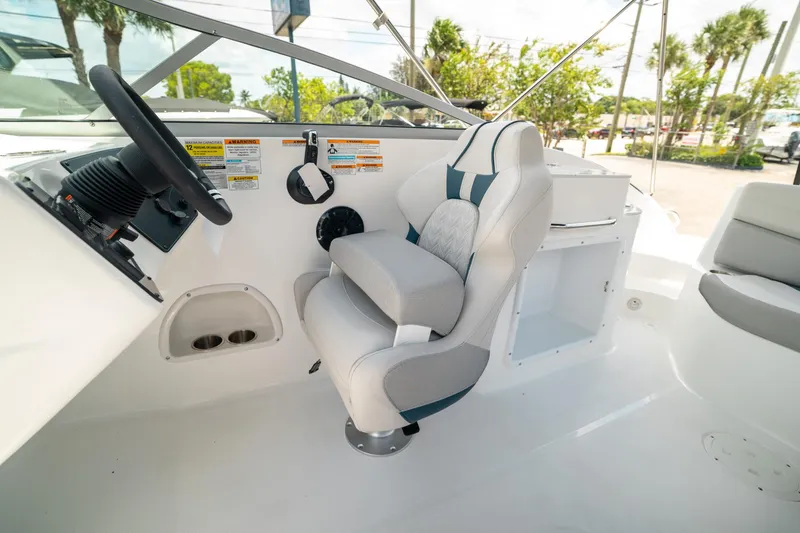 Slide: The Image of 2024 Hurricane SunDeck 2400 OB boat interior with steering wheel and captain's chair. - 23