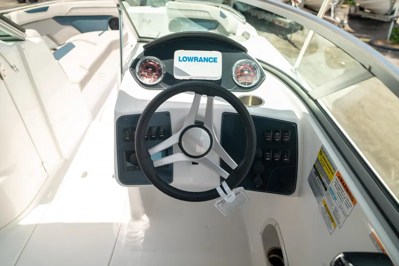 Slide: The Image of 2024 Hurricane SunDeck 2400 OB boat dashboard with steering wheel and control panel. - 25