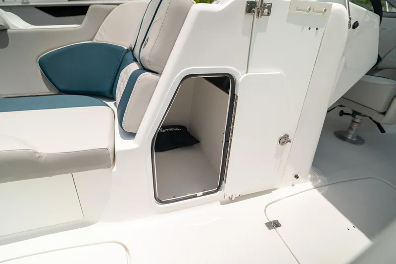 Slide: The Image of 2024 Hurricane SunDeck 2400 OB boat interior storage compartment with open door. - 35