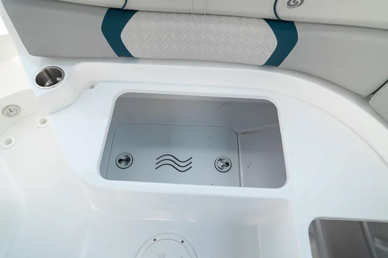 Slide: The Image of 2024 Hurricane SunDeck 2400 OB boat storage compartment with sleek design and cup holder. - 13