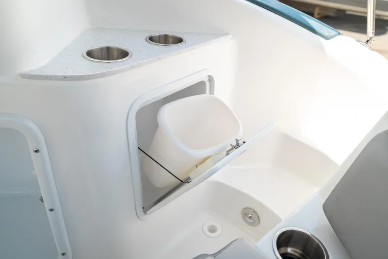 Slide: The Image of 2024 Hurricane SunDeck 2400 OB interior with cup holders and storage compartment. - 17