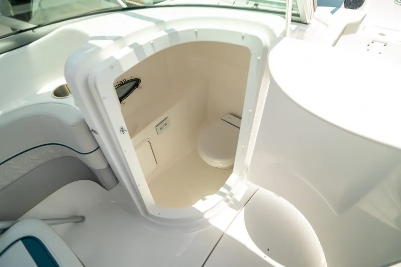 Slide: The Image of 2024 Hurricane SunDeck 2400 OB boat interior with compact restroom compartment. - 21