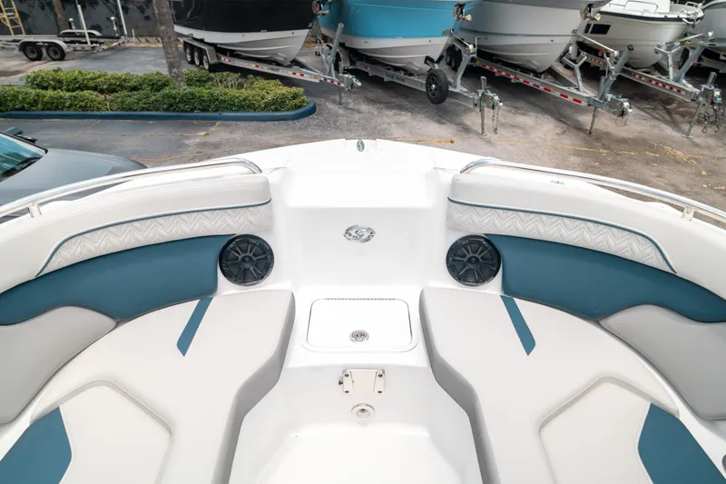 Slide: The Image of 2024 Hurricane SunDeck 2400 OB boat interior with cushioned seating and speakers. - 30