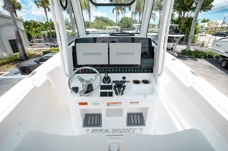 Slide: The Image of 2025 Sea Hunt Gamefish 28 FS boat cockpit with Garmin displays and steering wheel. - 24