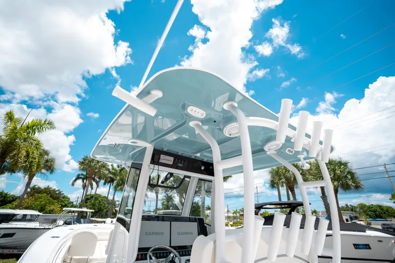 Slide: The Image of 2025 Sea Hunt Gamefish 28 FS boat with T-top and rod holders under a blue sky. - 29