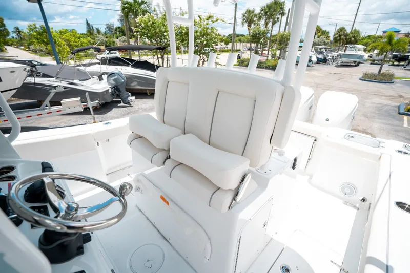 Slide: The Image of 2025 Sea Hunt Gamefish 28 FS boat interior with white seating and steering wheel. - 32