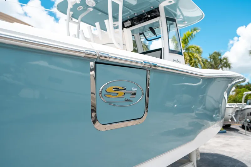 Slide: The Image of 2025 Sea Hunt Gamefish 28 FS boat, light blue hull, chrome logo, sunny day. - 10