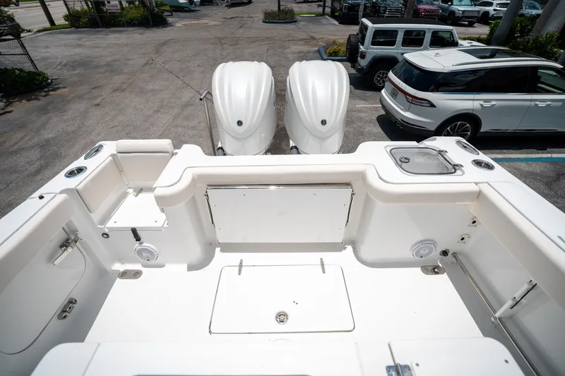 Slide: The Image of 2025 Sea Hunt Gamefish 28 FS boat deck with dual engines in a parking lot. - 12
