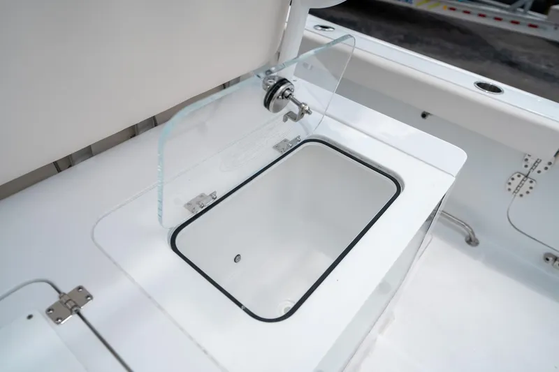 Slide: The Image of 2025 Sea Hunt Gamefish 28 FS boat livewell with glass lid and white interior. - 18