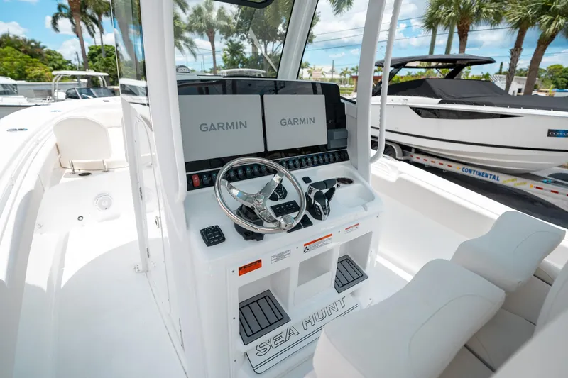 Slide: The Image of 2025 Sea Hunt Gamefish 28 FS boat cockpit with Garmin displays and dual seating. - 26