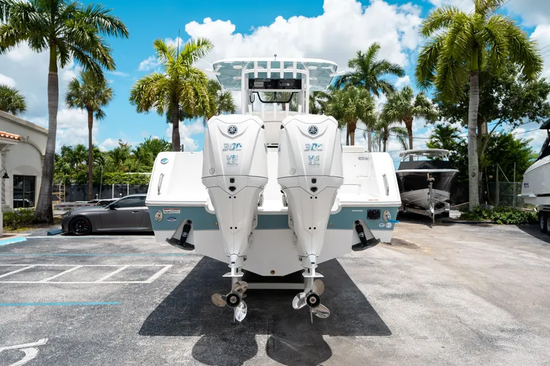 Slide: The Image of 2025 Sea Hunt Gamefish 28 FS boat with dual engines, parked outdoors under palm trees. - 3