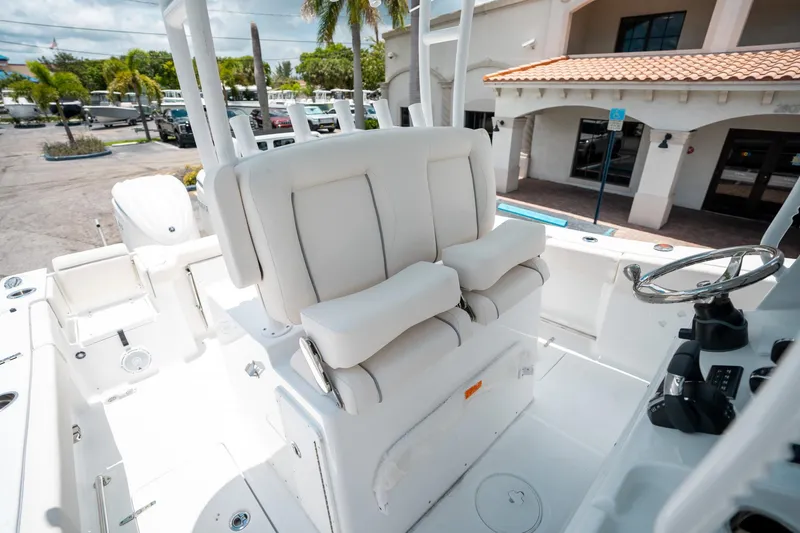 Slide: The Image of 2025 Sea Hunt Gamefish 28 FS boat interior with white seating and steering wheel. - 33