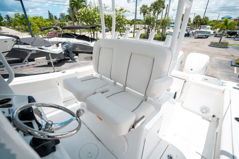 Slide: The Image of 2025 Sea Hunt Gamefish 28 FS boat interior with white seating and steering wheel. - 35