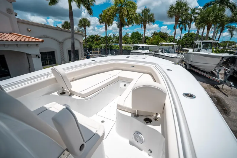 Slide: The Image of 2025 Sea Hunt Gamefish 28 FS boat interior with seating, surrounded by palm trees. - 40