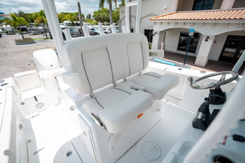Slide: The Image of 2025 Sea Hunt Gamefish 28 FS boat interior with white seating and steering wheel. - 34