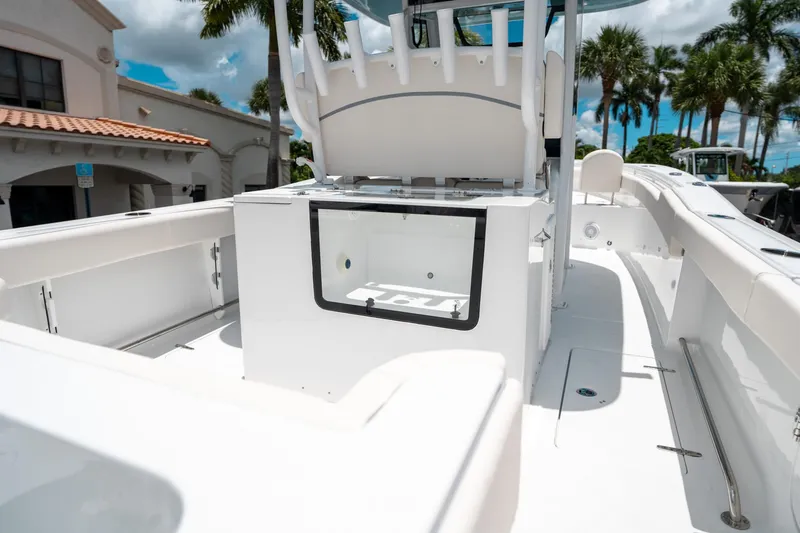 Slide: The Image of 2025 Sea Hunt Gamefish 28 FS boat interior with seating and storage, under a sunny sky. - 11