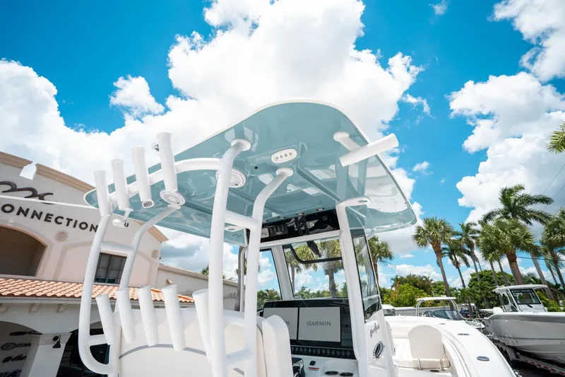 Slide: The Image of 2025 Sea Hunt Gamefish 28 FS boat with T-top under a bright blue sky. - 28