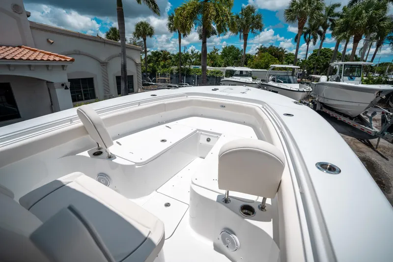 Slide: The Image of 2025 Sea Hunt Gamefish 28 FS boat interior with seating, surrounded by palm trees. - 42