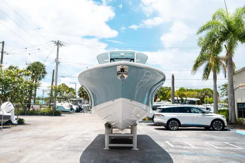 Slide: The Image of 2025 Sea Hunt Gamefish 28 FS boat displayed outdoors, with palm trees and cars nearby. - 7