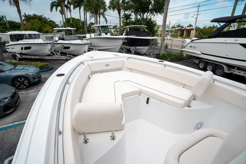 Slide: The Image of 2025 Sea Hunt Ultra 239 SE boat interior with white seating, parked among other boats. - 37