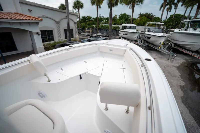 Slide: The Image of 2025 Sea Hunt Ultra 239 SE boat interior with seating, docked near other boats. - 44