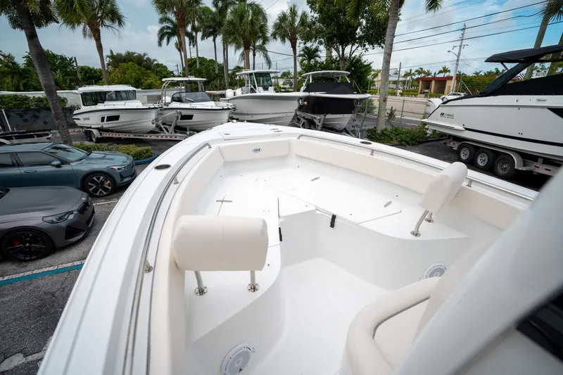 Slide: The Image of 2025 Sea Hunt Ultra 239 SE boat displayed in a marina with palm trees. - 45